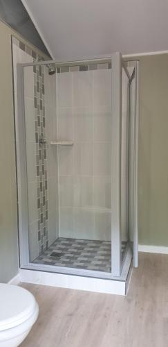 a shower stall in a bathroom with a toilet at Coral Divers in Sodwana Bay
