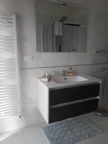 bagno bianco con lavandino e specchio di Appartamento Via Gentile a Foggia