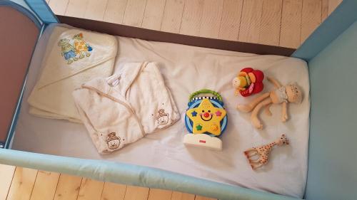 a crib with some baby items on it at Orfea s home - maison de charme, Lyons-la-Forêt, accès direct forêt in Le Tronquay
