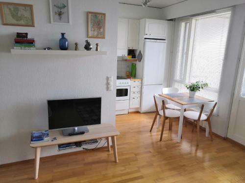 sala de estar con mesa y TV en Apartment with sauna near the Saimaa lake, en Lappeenranta