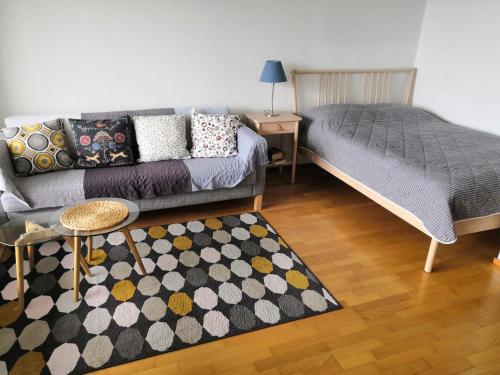 a living room with a couch and a bed at Apartment with sauna near the Saimaa lake in Lappeenranta