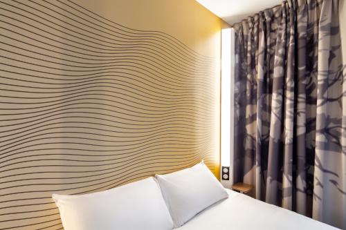 Ένα ή περισσότερα κρεβάτια σε δωμάτιο στο B&B HOTEL Paris Meudon Vélizy