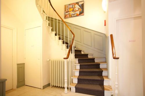a staircase in a home with white walls at Nadaud Hotel in Paris