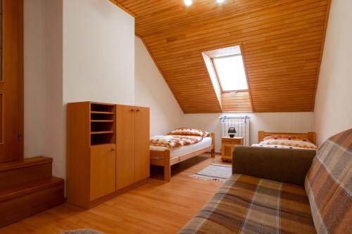 a attic room with two beds and a window at WOW Liptov Holiday House in Liptovský Mikuláš