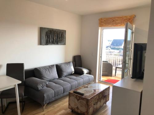 ein Wohnzimmer mit einem Sofa und einem TV in der Unterkunft Stilvolle Ferien-Geschäftswohnung Brandenburger Seenlandschaft in Werder