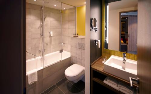 La salle de bains est pourvue d'une baignoire, de toilettes et d'un lavabo. dans l'établissement Holiday Inn - Hamburg - HafenCity, an IHG Hotel, à Hambourg