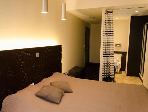 a bedroom with a bed with two pillows on it at Le Vieux Beffroi in Béthune