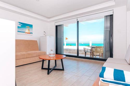 uma sala de estar com um sofá e uma mesa em Villas Marlin 108, a pie de playa, albercas, jacuzi, ubicacion inmejorable em Cancún