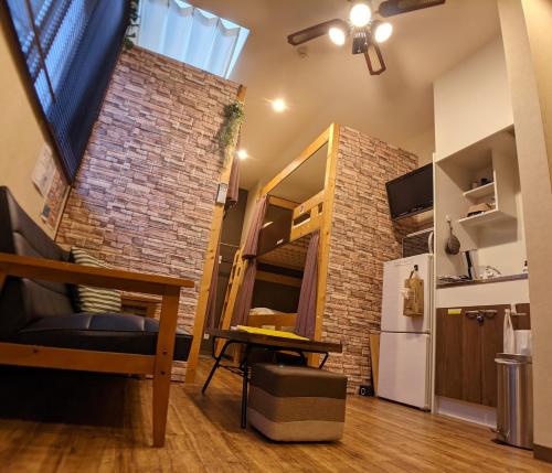 a small room with a brick wall and a refrigerator at TOMARO Osaka Bay in Osaka