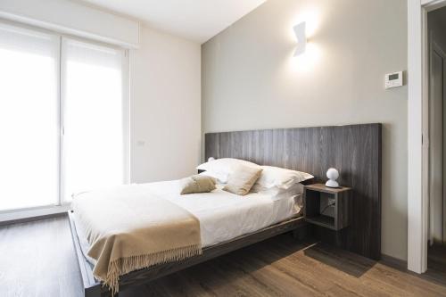 una camera con un grande letto con testiera in legno di Contempora Apartments - Cavallotti 13 - A63 a Milano