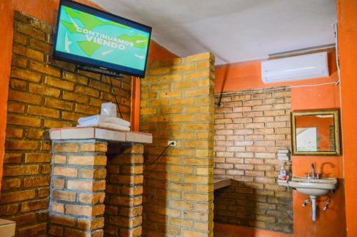 baño con lavabo y TV en una pared de ladrillo en Hotel Quinta San Jorge en Tula
