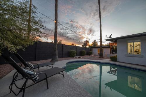 a swimming pool with two chairs next to a house at Phoenix Arcadia Turney home in Phoenix