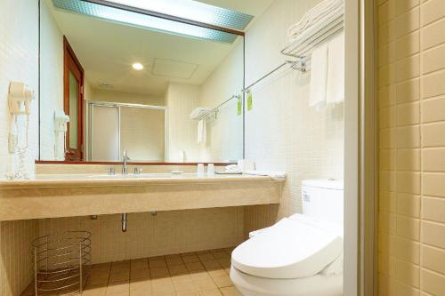 y baño con aseo, lavabo y espejo. en Aspire Resort en Longtan