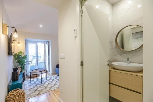a bathroom with a sink and a mirror at LovelyStay - Downtown Studio with Pool, AC and Balcony in Porto