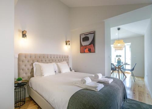 a bedroom with a large bed with towels on it at LovelyStay - Downtown Studio with Pool, AC and Balcony in Porto