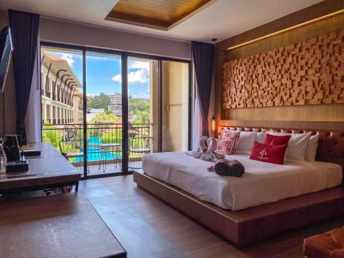 a bedroom with a large bed and a balcony at Aurico Kata Resort & Spa - SHA Extra Plus in Kata Beach