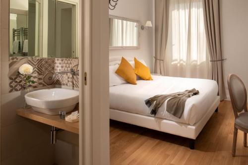 ローマにあるDomus Serafinoのベッドルーム(シンクと鏡付きのベッド付)
