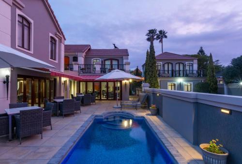 a swimming pool in front of a house at Villa Tuscana in Port Elizabeth