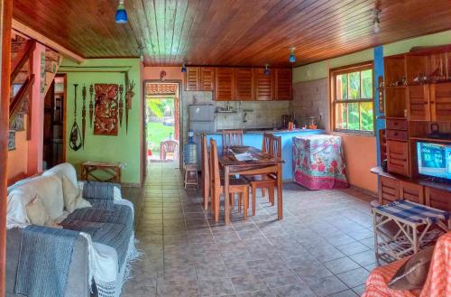 a living room with a table and a kitchen at Feriasmares in Ilhéus