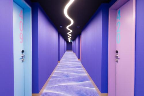 a hallway with purple walls and a light on the ceiling at Prize by Radisson, Rostock City in Rostock