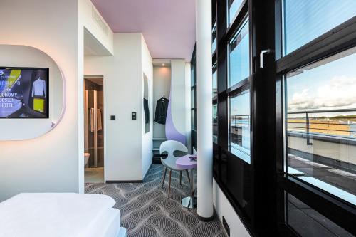 a bedroom with a bed and a tv and a window at Prize by Radisson, Rostock City in Rostock