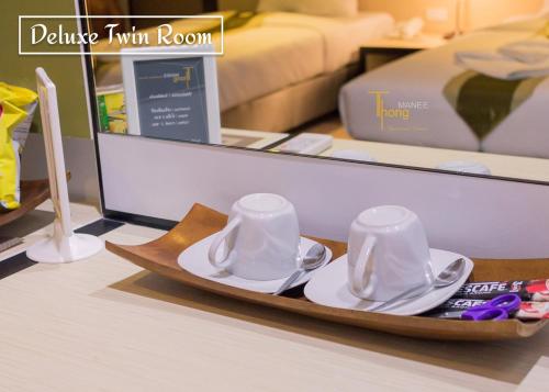 a tray with saucers and plates on a table at Thongmanee Hotel in Hat Yai