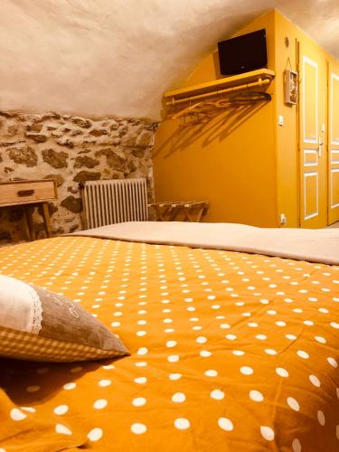 a bedroom with a large bed with a yellow at L'Atelier de Marie in Eyguières