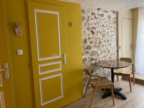 a room with a yellow door and a table at L'Atelier de Marie in Eyguières