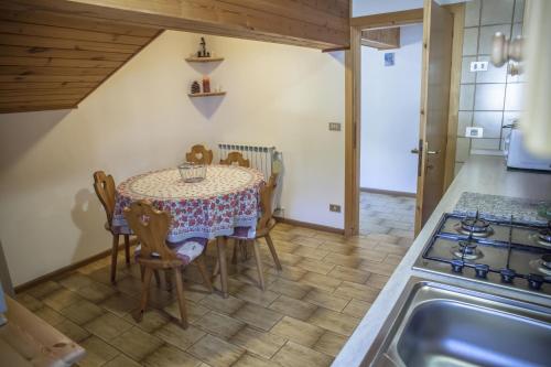 cocina y comedor con mesa y sillas en Apartments Ospitalità Diffusa Borgate tra le Malghe, en Falcade