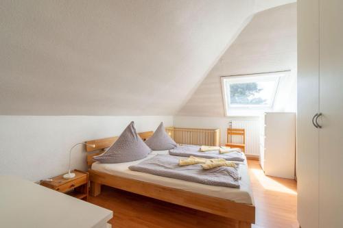 ボルクムにあるFerienhaus-Butenboerkumerのベッドルーム1室(枕付きのベッド1台、窓付)