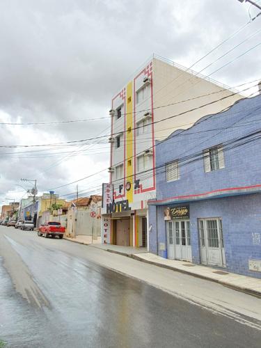 a street with a blue building on the side of a road at Fox Hotel Montes Claros in Montes Claros