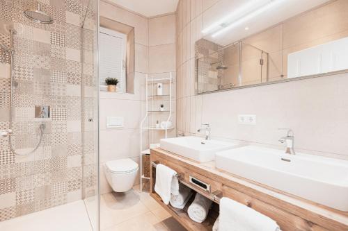łazienka z 2 umywalkami, prysznicem i toaletą w obiekcie Top Center-Apartment - Wohnung im Stadtzentrum in perfekter Lage & Balkon w mieście Innsbruck