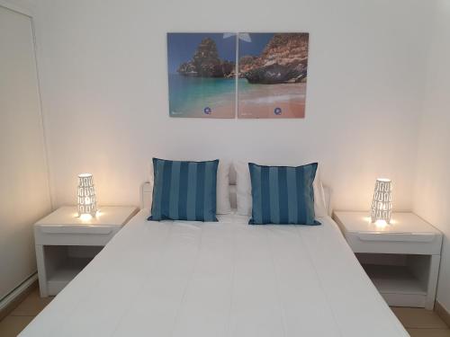 a white bed with two lamps on two tables at T1 Praiamar 3 Vista Fabulosa in Quarteira