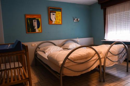 - une chambre avec un lit dans une pièce aux murs bleus dans l'établissement Kwakkelnest, à Poperinge