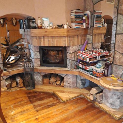 a fireplace in a living room with a stone wall at Lauku māja in Līgo