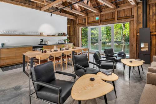 a room with tables and chairs and a kitchen at Boen Gård in Kristiansand