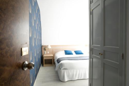 ベレームにあるHôtel Résidence Normandy Country Club by Popinnsのベッドルーム1室(青い枕のベッド1台付)
