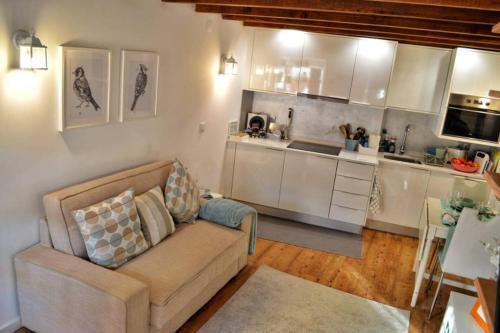 a living room with a couch and a kitchen at Casinha de Belém in Lisbon