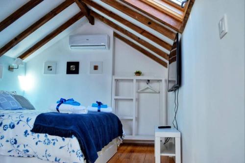 a bedroom with a bed with a blue comforter at Casinha de Belém in Lisbon