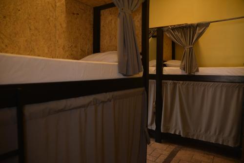 two bunk beds in a room with curtains at TAS D VIAJE Suites - Hostel Boutique in Punta del Este
