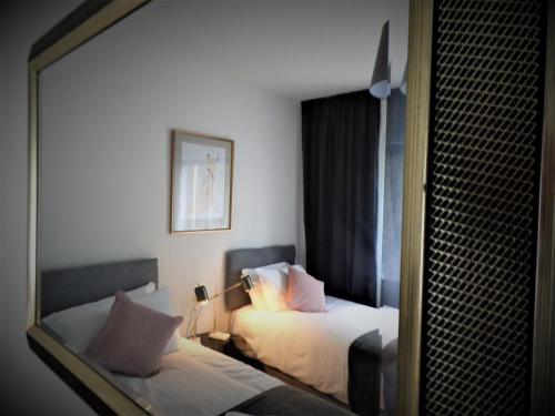 Una habitación de hotel con dos camas y un espejo. en Penilee Upper Apartment, en Glasgow
