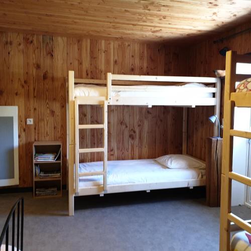 two bunk beds in a room with wooden walls at Mas de Reilhanette in Montbrun-les-Bains