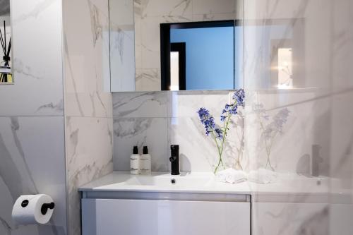 a bathroom with a sink with a vase of flowers on it at Boutique Hotel 43 in Koog aan de Zaan