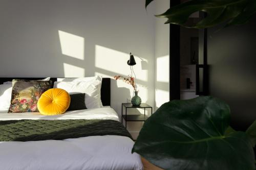 a bedroom with a bed with a yellow pillow on it at Boutique Hotel 43 in Koog aan de Zaan