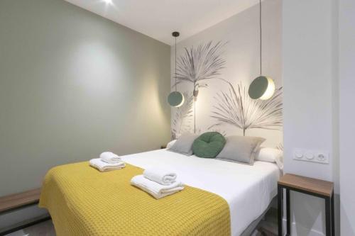 1 dormitorio con 1 cama con 2 toallas en The Rentals Collection - Getaria, en San Sebastián