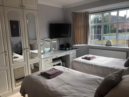a hotel room with two beds and a television at Redcot holiday bungalow in Peover Superior