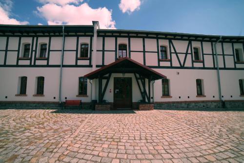 a large white building with a red bench in front of it at Noclegi Stara Wozownia in Piła