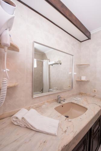 a bathroom with a sink and a mirror at Hotel Sablón in Llanes