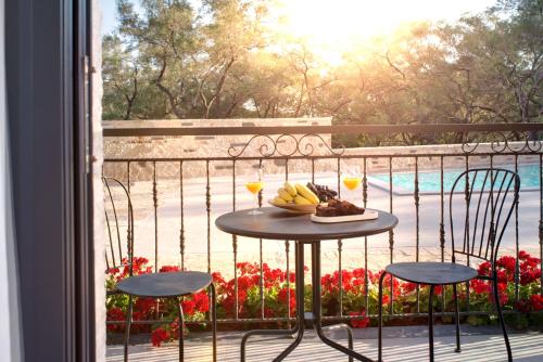 a table with a plate of food and drinks on a balcony at Charisma Boutique Hotel in Parga