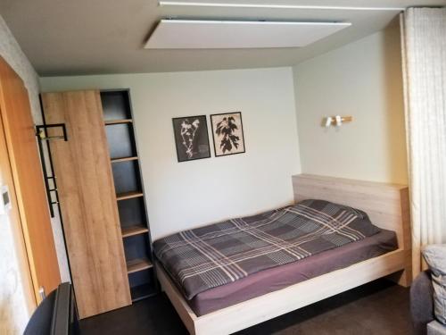 een kleine slaapkamer met een bed en planken bij Fajn Apartment in Šempeter v Savinjski Dolini